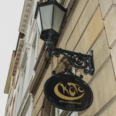 a sign hanging on the side of a building at Koto Garden Suites in Antwerp