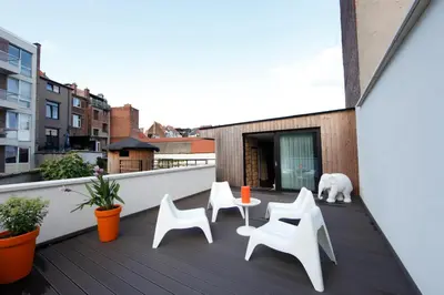 a balcony with white chairs and a white polar bear at Koto Garden Suites in Antwerp