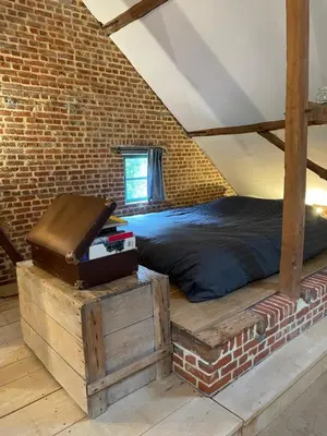 a bedroom with a bed and a brick wall at Art Of Einstein in Diest