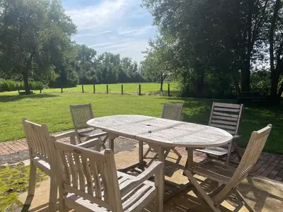 a picnic table with four chairs and a field at Art Of Einstein in Diest