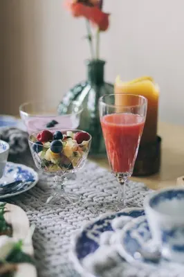 a table with two wine glasses and a bowl of fruit at B&B de ZIL in Herselt