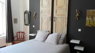 a bedroom with a white bed with a wooden door at Villa 36 B&B in Brussels