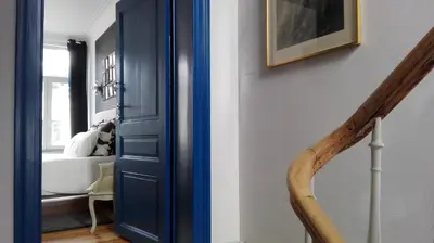 a hallway with a blue door and a stair case at Villa 36 B&B in Brussels