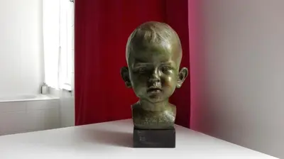 a bronze statue of a boy sitting on a table at Villa 36 B&B in Brussels