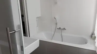 a white bathroom with a shower and a tub at Villa 36 B&B in Brussels
