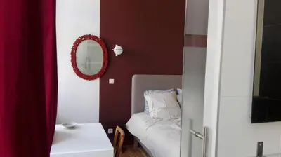 a living room with a couch and a mirror at Villa 36 B&B in Brussels