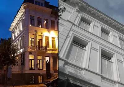 a white building next to a building with the light on at Hotel Goodnight Antwerp in Antwerp
