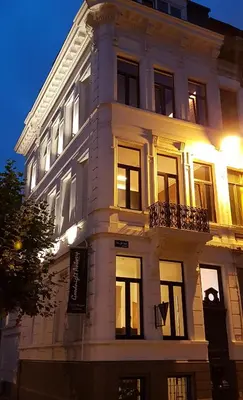 a white building with windows and a clock on it at Hotel Goodnight Antwerp in Antwerp