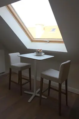 a table and two chairs with a cake on a window at ZevenVrijeDagen in Ghent