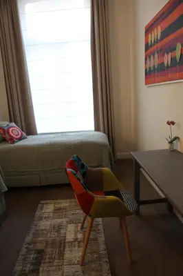 a living room with a chair and a window at ZevenVrijeDagen in Ghent