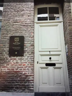 a white door on the side of a brick building at ZevenVrijeDagen in Ghent