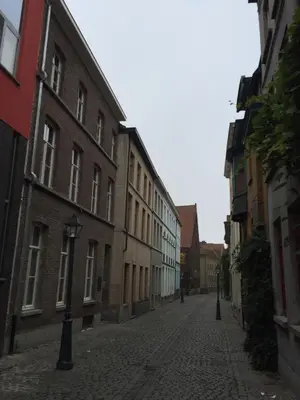 an empty city street with buildings and a street light at ZevenVrijeDagen in Ghent
