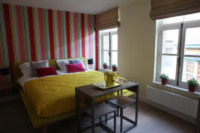 a bedroom with a yellow bed and a side table at ZevenVrijeDagen in Ghent