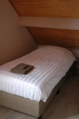a bed with a hat sitting on top of it at Holiday Home near town in Aarschot