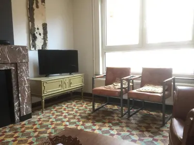 a living room with two chairs and a flat screen tv at Holiday Home near town in Aarschot