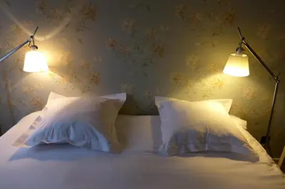 a bedroom with two white pillows and two lights at CitytripGent Apartment in Ghent