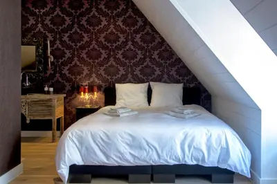 a bedroom with a large white bed in a attic at B&B Vinedo in Zele