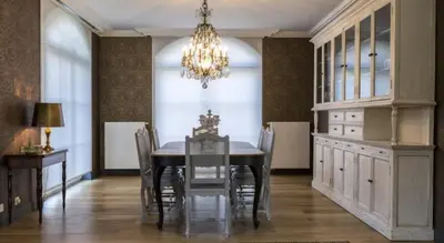 a dining room with a table and chairs and a chandelier at B&B Vinedo in Zele