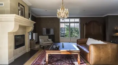 a living room with a couch and a fireplace at B&B Vinedo in Zele