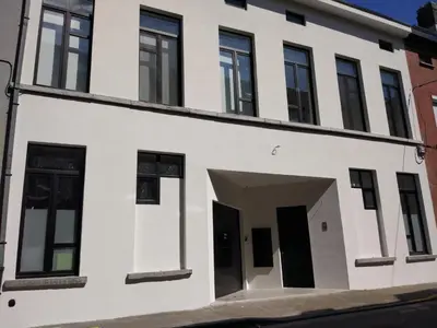 a white building with a doorway and windows at Stay in Ghent in Ghent