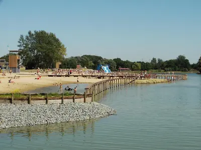a group of people on a beach near a pier at Stay in Ghent in Ghent