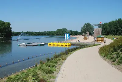 a path next to a lake with boats in the water at Stay in Ghent in Ghent