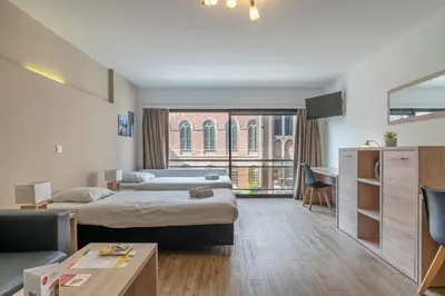a hotel room with two beds and a tv at Value Stay Residence Mechelen in Mechelen