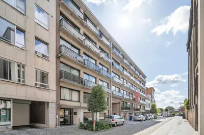 an apartment building on a street with a tree in front at Value Stay Residence Mechelen in Mechelen