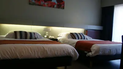 a hotel room with two beds and a window at De Basiliek in Edegem