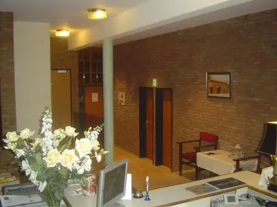 a room with a desk with a vase of flowers at De Basiliek in Edegem