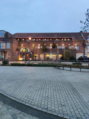 a large brick building with a courtyard in front of it at De Basiliek in Edegem
