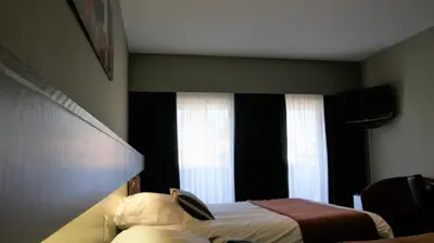 a hotel room with a bed and a window at De Basiliek in Edegem