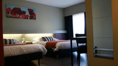 a hotel room with two beds and a window at De Basiliek in Edegem