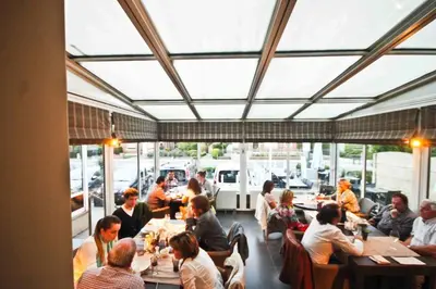 a group of people sitting at tables in a restaurant at Hotel de modern in Diest