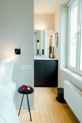 a bedroom with a bed and a table and a sink at The House of Edward by Domani Hotels in Ghent