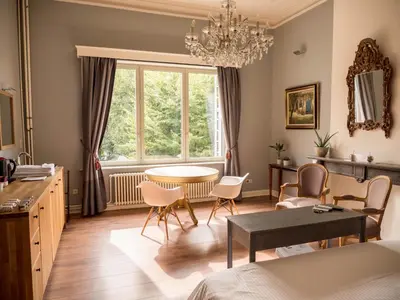 a living room with a table and chairs and a window at Maison Willem Tell in Ghent