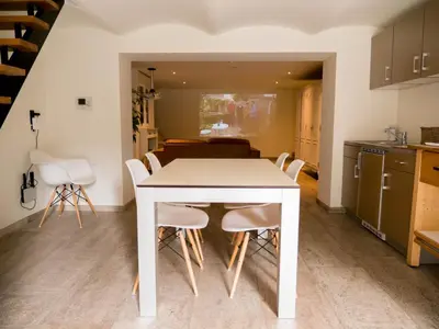 a kitchen and dining room with a white table and chairs at Maison Willem Tell in Ghent