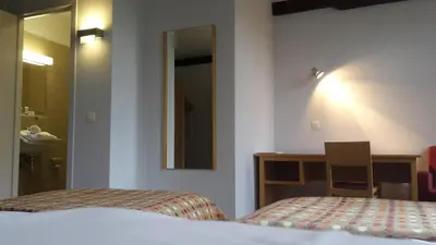 a bedroom with a bed and a desk and a mirror at Irish College Leuven in Leuven