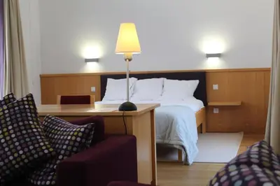 a hotel room with a bed and a table and chairs at Irish College Leuven in Leuven