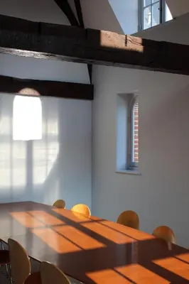 a long wooden table in a room with chairs at Irish College Leuven in Leuven