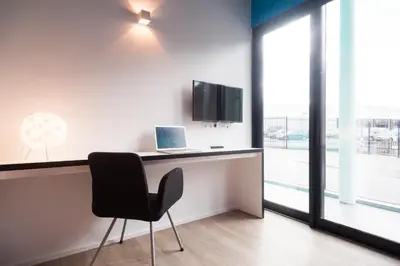 a desk with a laptop and a chair in a room at Ooostel2.be Zaventem in Zaventem