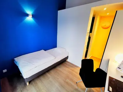 a small room with a white bed and a desk at Ooostel2.be Zaventem in Zaventem