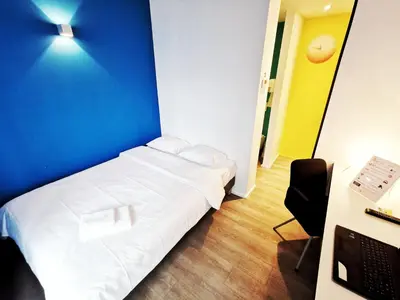 a small room with a bed and a desk with a computer at Ooostel2.be Zaventem in Zaventem