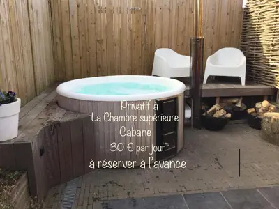 a jacuzzi tub in a backyard with a sign at B&B L'Eau Claire in La Hulpe