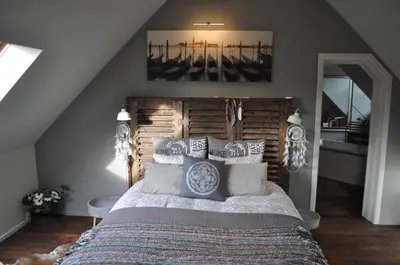 a bedroom with a large bed with a wooden headboard at B&B L'Eau Claire in La Hulpe
