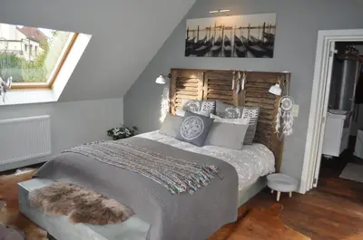 a bedroom with a large bed with a wooden headboard at B&B L'Eau Claire in La Hulpe