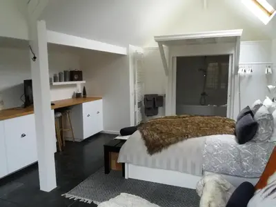 a bedroom with a bed and a desk in it at B&B L'Eau Claire in La Hulpe