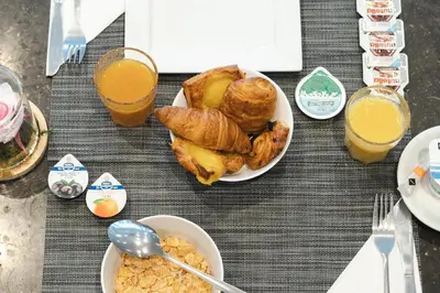 a table with a plate of breakfast foods and orange juice at Hotel Chambord in Brussels