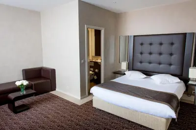 a hotel room with a large bed and a chair at Hotel Chambord in Brussels