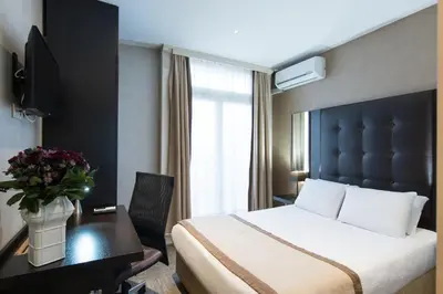 a hotel room with a bed and a desk and a bed sidx sidx at Hotel Chambord in Brussels